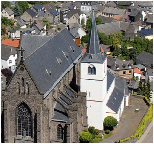Eine Doppelkirche, die linke größer und aus Basaltstein, die rechte kleiner und weiß